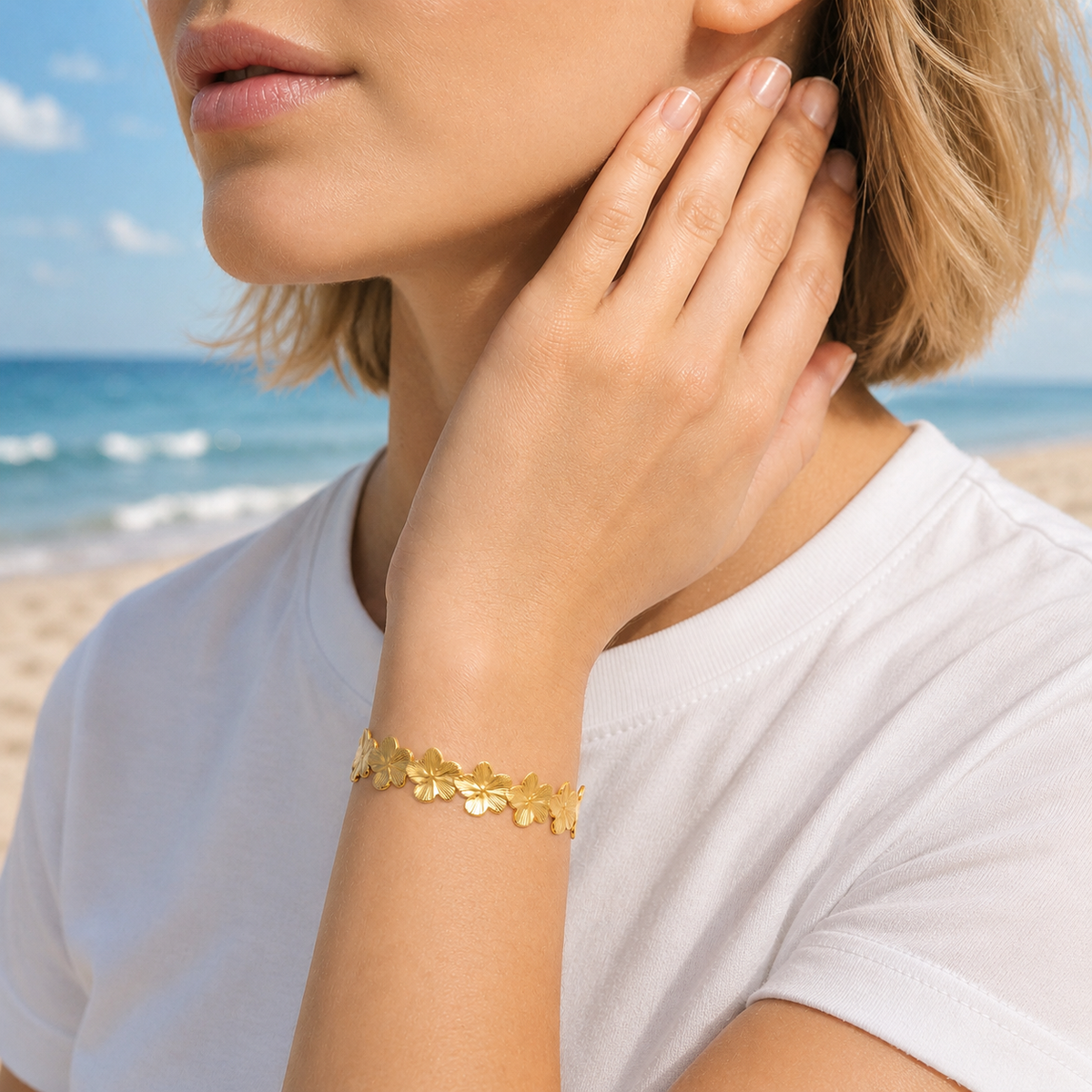 Woman wearing a gold floral bracelet on a beach