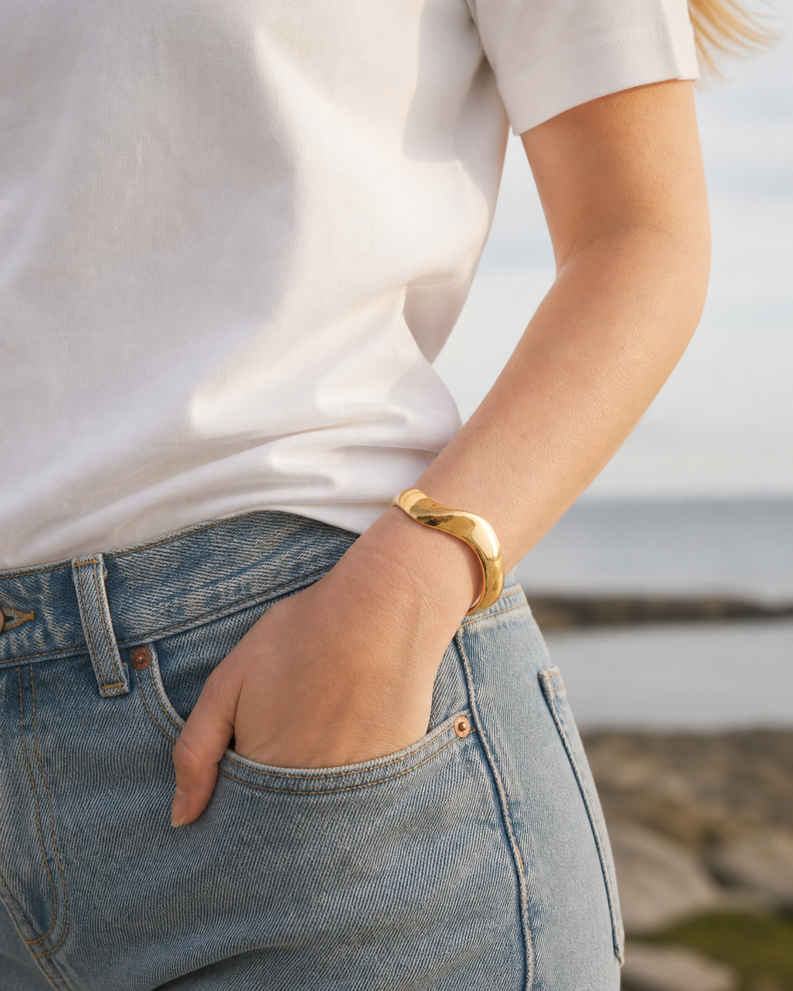 HNKO wave cuff bracelet in gold PVD stainless steel on model wrist, minimalist Nordic jewellery